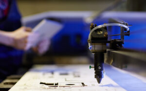 Técnico dando soporte a router CNC MultiCam en taller industrial